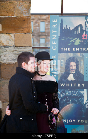 Whitby, Yorkshire, England, goth, gothic couple at Whitby goth weekend posing in front of visitor centre Stock Photo