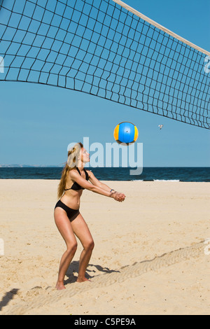 Attractive woman plays in beach volleyball Stock Photo