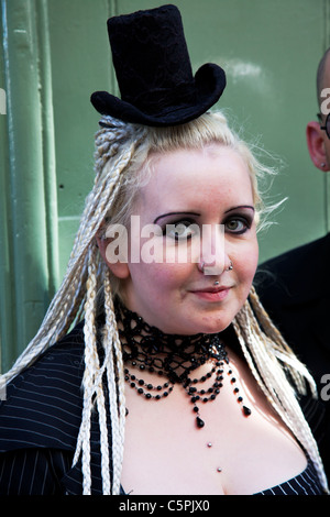 Whitby, Yorkshire, England, goth woman with piercings in nose and lip with hat too small for her head, blond dreadlocks Stock Photo