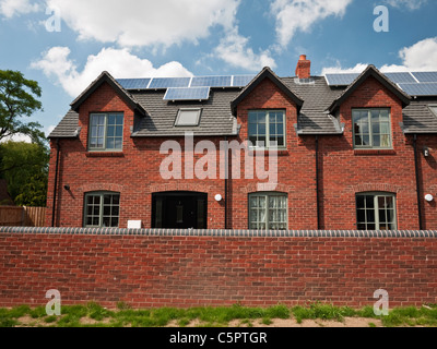 Solar PV panels mounted on a new housing development in the South Staffordshire village of Swindon Stock Photo