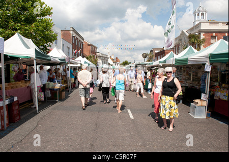 Shoppers stroll around a street market in Christchuch, Dorset, on a warm summer’s day. Stock Photo