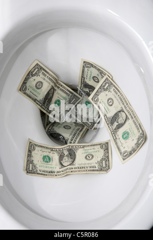 flushing us dollar bills down the toilet Stock Photo