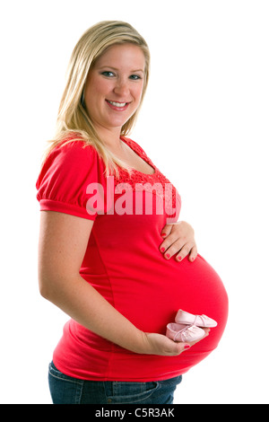 Smiling pregnant woman holds a pair of baby booties in her hand. Stock Photo
