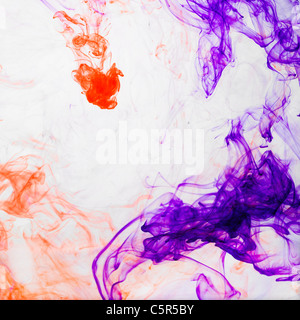 Orange and purple ink dissolving in water Stock Photo