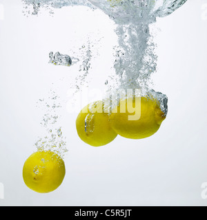 Lemons dropped into water Stock Photo
