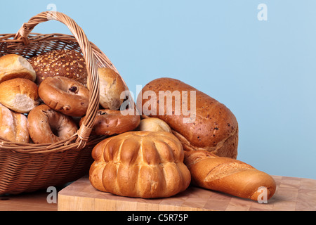 Photo of different types of bread spilling out from a basket. Stock Photo