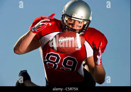 American Football player focused on making the catch. Stock Photo