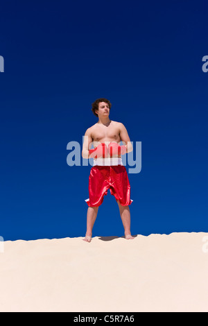 A boxer standing on dunes, gloves connected. Stock Photo