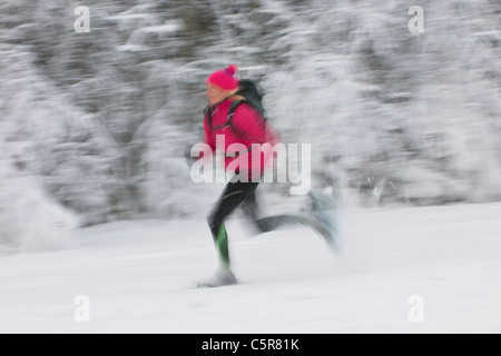 A runner moving at speed through a snowy landscape. Stock Photo