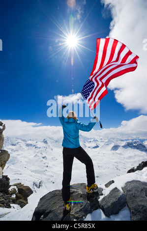 An American mountaineer punches the this air and celebrates on top of the World. Stock Photo