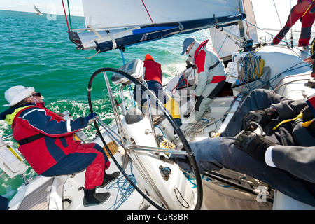 An offshore yacht racing crew busy sailing on the Ocean. Stock Photo