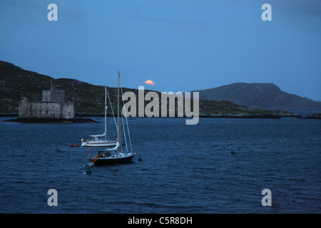 full moon rising over Castlebay during the longest day the largest community on the Island of Barra in the Outer Hebrides Stock Photo