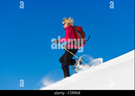 Snowshoeing fast down deep powder snow. Stock Photo