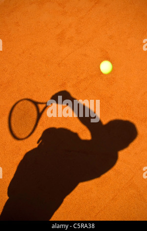 The silhouette of a tennis player serving. Stock Photo