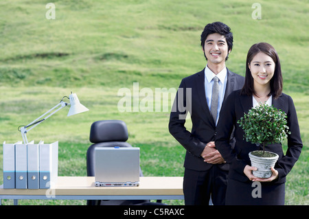 Two people standing together in front of a desk Stock Photo