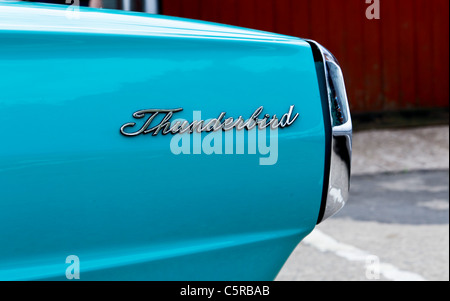 A 1965 pale blue Ford Thunderbird convertible with a mature couple driving in it Stock Photo