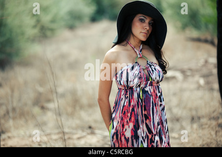 Serious young Hispanic woman wearing black hat outdoors Stock Photo