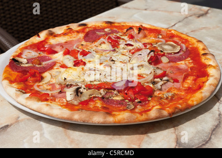 Close up of pizza Ariecchino prepared with mozarella cheese, mushrooms, boiled ham, salami and onions Stock Photo
