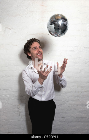 Mid adult man looking at disco ball Stock Photo