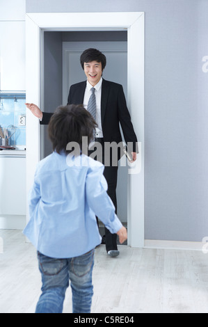 A son greeting his father coming home Stock Photo