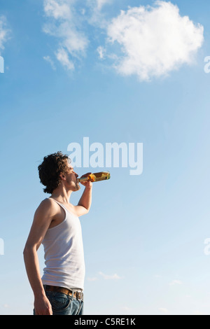 Germany, Hamburg, Mid adult man drinking and reading newspaper near Elbe river, smiling, portrait Stock Photo