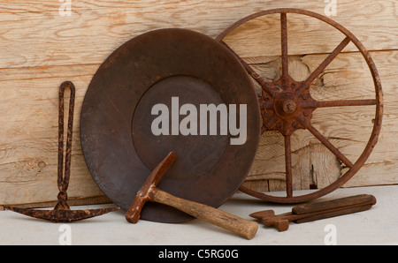 Old mining tools: wheel, picks, ax, gold pan. Stock Photo