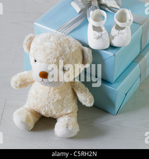 Teddy bear, baby's shoes and presents Stock Photo