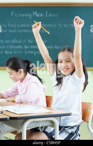 Two Asian girls sitting at desks Stock Photo
