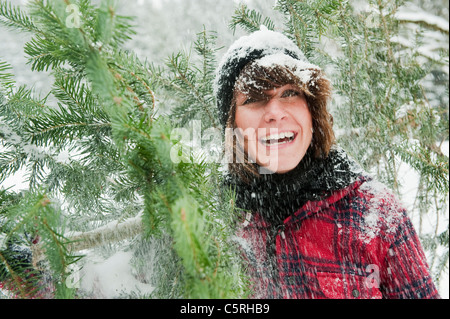 Austria, Salzburg Country, Flachau, Young woman holding christmas tree Stock Photo