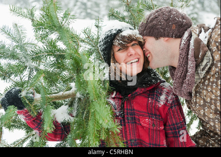 Austria, Salzburg Country, Flachau, Young man and woman holding christmas tree Stock Photo