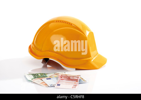 Hardhat and different Euro bank notes in foreground Stock Photo