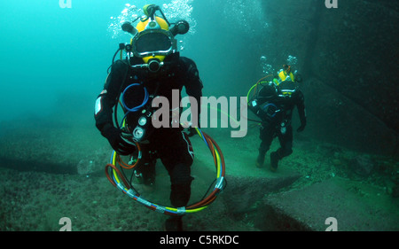 Navy divers walking along the ocean floor during diving operations Stock Photo