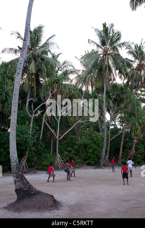 Boys playing football on the beach, The Maldives Stock Photo