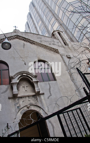 A church with barbed wire and a high rise building, Istanbul, Turkey Stock Photo