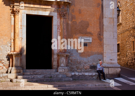 Older man relaxing outside Chiesa di Santa Caterina, Taormina Messina Sicily Italy Stock Photo