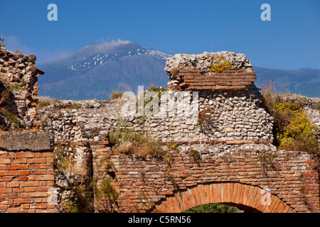 Ruins of the Greek Theatre (Teatro Greco) in Taormina with smoking Mt. Etna beyond, Sicily Italy Stock Photo