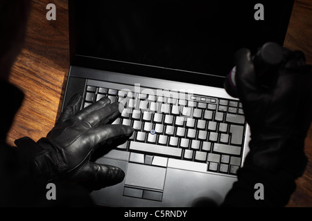 Man stealing data from a laptop Stock Photo