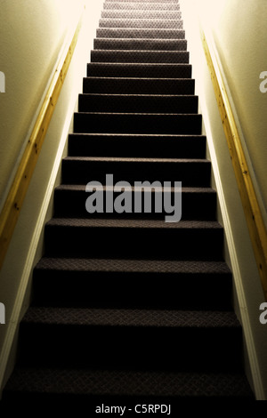 A old stair well leads up into the light Stock Photo