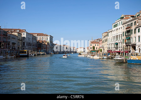 Venice, the Grand Canal between old historic buildings.  Hotels lining the canal with many boats transportin goods and people. Stock Photo