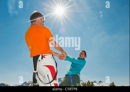 Austria, Salzburg Country, Altenmarkt-Zauchensee, Mid adult couple holding hands and spinning in winter Stock Photo