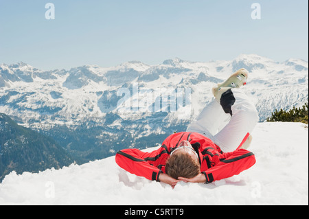 Austria, Salzburg Country, Altenmarkt-Zauchensee, Mid adult man lying on snow in winter Stock Photo