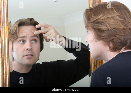 man looking into mirror Stock Photo