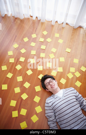 man stretched his arms out lying on the floor Stock Photo