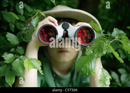 Germany, Bavaria, Close up of boy looking through binocular in forest Stock Photo