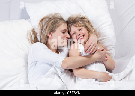 Germany, Bavaria, Munich, Mother and daughter lying on bed