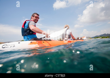 A couple in a double kayak at Skala Eresou on Lesbos, Greece. Stock Photo