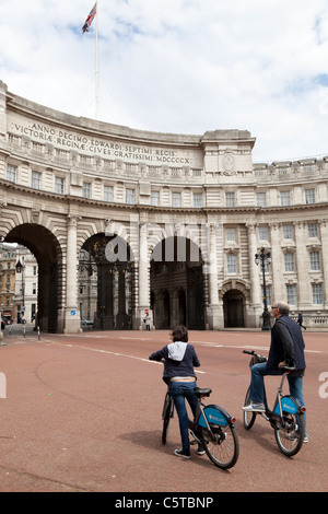 two people on Barclays Cycle Hire scheme London bikes by admiralty arch Stock Photo