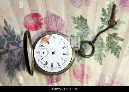 old pocket watch on handmade paper with leaves Stock Photo