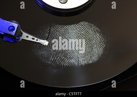 Computer hard drive, opened with writing/reading head and hard disc. Fingerprint on hard disk, symbol photo. Stock Photo