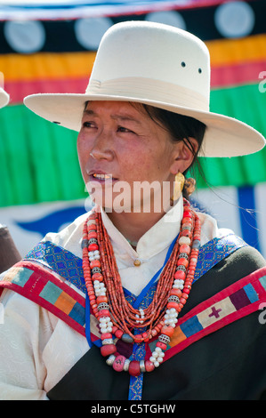 Dressed in traditional ethnic Tibetan dress, woman waits turn to sing at folk festival, Haibei, Qinghai Province, China Stock Photo